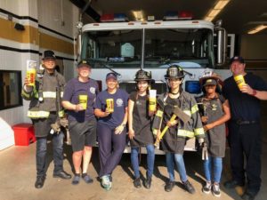 Firefighters Pose with Big Yellow Cup