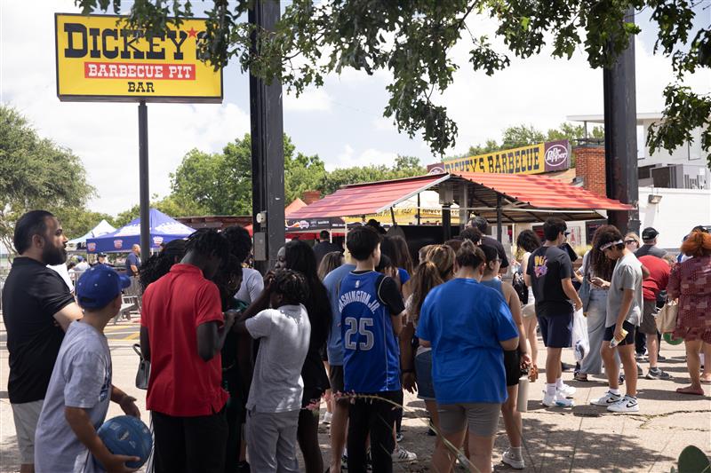 Crowd of customers waiting in line outside Dickey’s Barbecue Pit during a busy summer event, showcasing high foot traffic, strong brand visibility, and customer engagement at the popular BBQ restaurant.